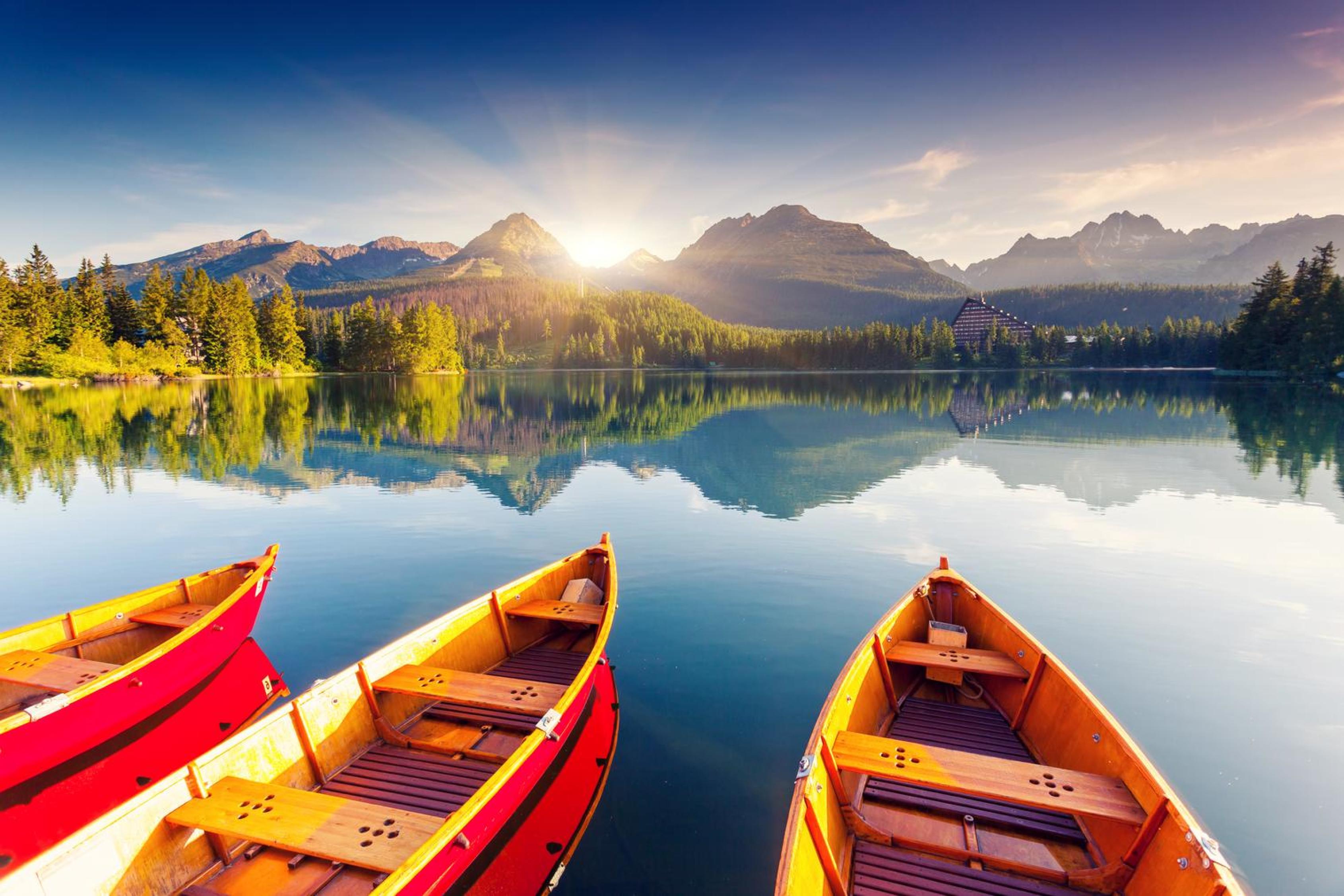 Boats at the edge of a lake with mountains in the background